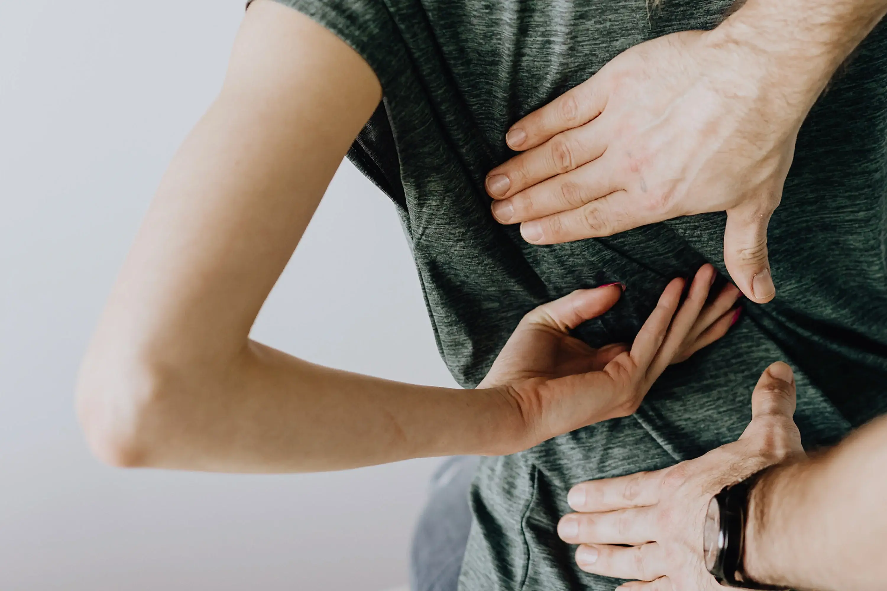 three hands touching a persons back